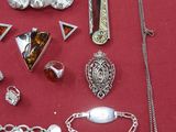 de nombreux bijoux en argent posés sur une table rouge
