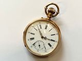 a gold pocket watch with roman numerals on it
