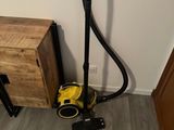 the vacuum is on the floor next to a wooden cabinet