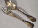 two spoons and a fork sitting on a table