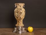 a vase and an apple sitting on a wooden table