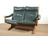 a green leather couch sitting on a carpeted floor