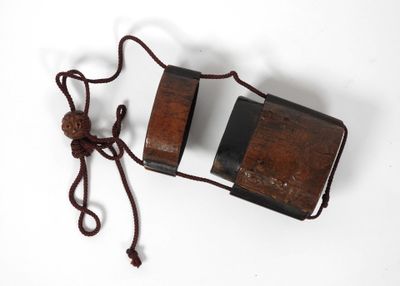 une vieille boîte en bois entourée d'une ficelle, posée sur une surface blanche