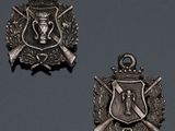 three medals are displayed on a gray surface with a black background