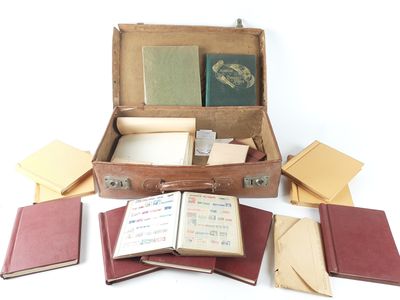 a suitcase filled with books and papers on a white surface