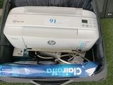 une imprimante posée dans une valise, sur l'herbe