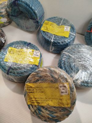 de nombreuses pelotes de laine emballées dans du film alimentaire, posées sur une table