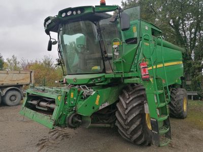 un tracteur vert garé sur le bord de la route