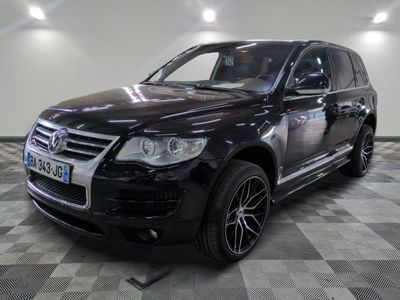 the black volkswagen suv is parked on a checkered tile floor