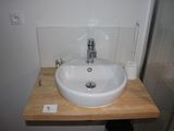 a white sink sitting on a wooden counter in a bathroom