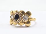 a close up of a gold ring with a sapphire and diamonds