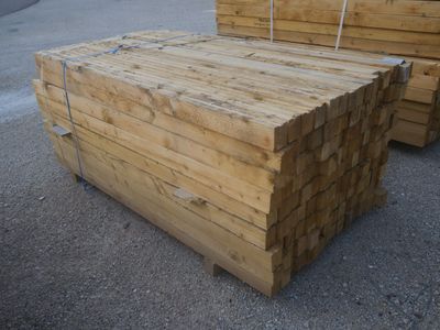 plusieurs morceaux de bois sont empilés sur un parking