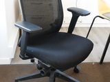 une chaise de bureau noire avec une assise noire et un dossier jaune