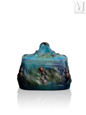 une image représentant un vase bleu orné de fleurs, posé sur une surface blanche