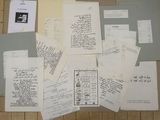 a pile of papers on the floor next to a laptop