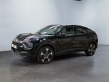 the black suv is parked in a large room with a white wall