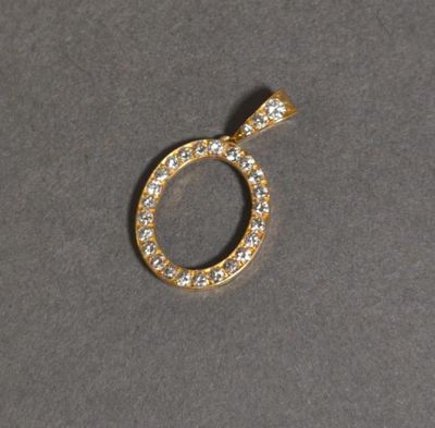 un gros plan d'un pendentif en diamant posé sur une surface grise