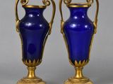 pair of blue glass vases with gold accents on stands