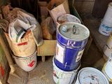 many buckets of paint sitting on the floor in a room