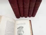 six old books sitting on top of a white table next to each other