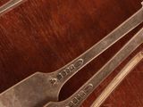 several spoons and forks on a wooden table with a cup of coffee