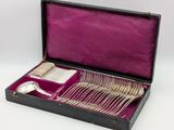 silverware in a black case with purple lining on a white background