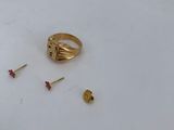a gold ring and two screws on a white surface
