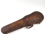 an old guitar case sitting on top of a white surface