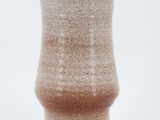 a close up of a vase on a white surface