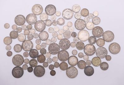 a pile of old silver coins on a white surface