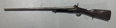 un pistolet posé sur une table, avec un couteau planté en son milieu