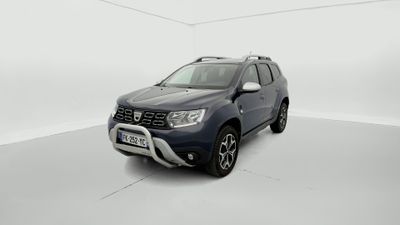 Une Dacia bleue est garée dans une pièce blanche