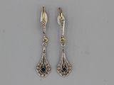 une paire de boucles d'oreilles en argent et en or ornées de pierres noires