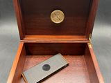 an open wooden box with a lighter in it on a table
