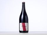 a bottle of red wine sitting on top of a table