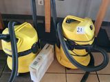 two yellow vacuums sitting on the floor next to each other