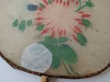 an old fan with a painting of a bird on it