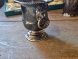 a silver cup sitting on a table next to a box