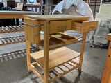 une table en bois surmontée d'une étagère, au milieu d'une pièce