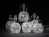 six clear glass vases sitting on top of a black table