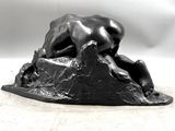 statue of a man laying down on a rock with his head on the ground