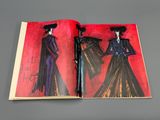 an open book with a drawing of a woman in a black dress and a man in a red hat