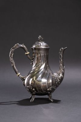 une théière ancienne en argent, ornée d'une anse en forme de dragon, sur fond gris