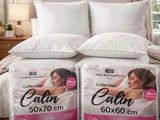 two pillows on top of a bed in a bedroom next to each other