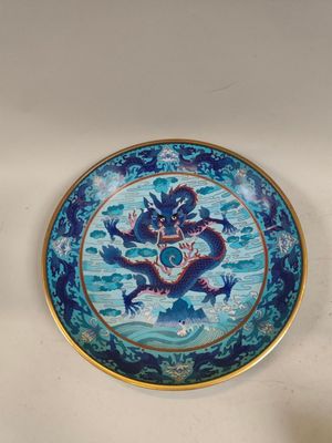 une assiette bleue ornée d'un dragon, posée sur une table
