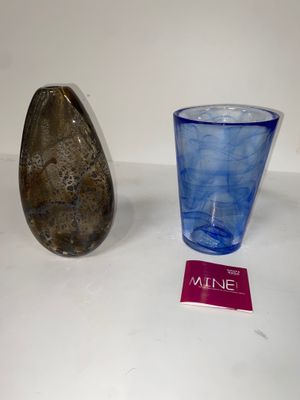 un verre et un caillou posés sur une table, à côté d'un verre à vin