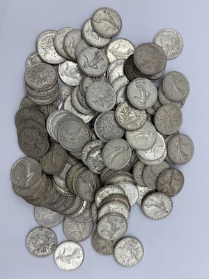 une pile de pièces d'argent posée sur une surface blanche