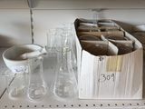 une boîte contenant des verres vides, posée sur une étagère