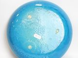 a blue frisbee that is sitting on a white surface