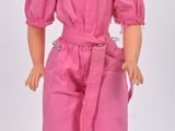 poupée Barbie vêtue d'une combinaison rose, d'un haut rose et de chaussures marron